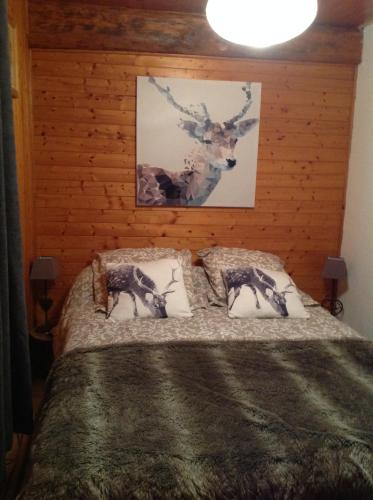 a bedroom with a bed with two deer prints on the wall at Appartement St Nicolas in Saint-Gervais-les-Bains