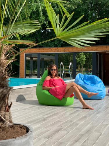 a woman sitting in a bean bag chair by a pool at Mohácsi Wellness Vendégház és Lovasklub in Mohács