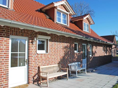a brick house with two benches in front of it at Ferienhaus Lobbe - WG 02 über zwei Etagen, strandnah in Lobbe