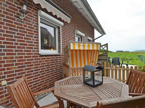 a wooden table and chairs on a patio at Ferienhaus Lobbe - WG 02 über zwei Etagen, strandnah in Lobbe