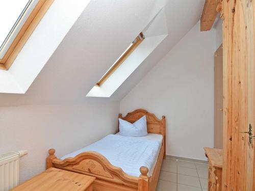 a bedroom with a bed and a wooden table at Ferienhaus Lobbe - WG 02 über zwei Etagen, strandnah in Lobbe