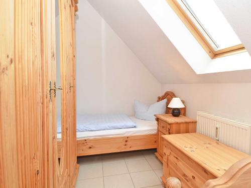 a small bedroom with a bed and a skylight at Ferienhaus Lobbe - WG 02 über zwei Etagen, strandnah in Lobbe