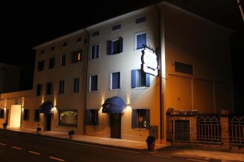 a building with a sign on the side of it at night at Hotel Calvi-Ristorante Mainor in Vittorio Veneto