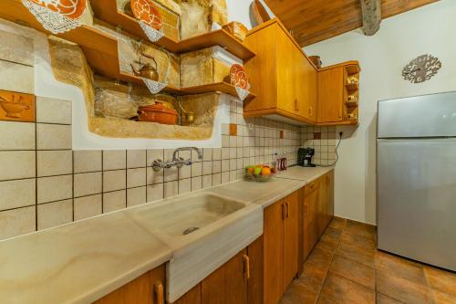Embrósneros的住宿－Villa Areti - Traditional Cozy Villa，厨房配有水槽和冰箱