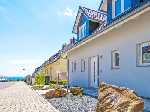 una casa con dos rocas grandes delante de ella en Auszeit Luxusappartment mit Meerblick und Infrarot Kabine, en Sassnitz