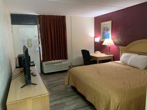 Habitación de hotel con cama y TV de pantalla plana. en Super Inn, en Tillmans Corner