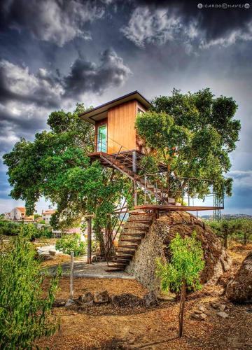 una casa en la parte superior de un árbol con escaleras en 2 bedrooms bungalow with city view shared pool and jacuzzi at Pinhel, en Pinhel