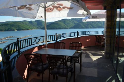 a table and chairs on a balcony with a view of the water at MOBI DICK Family Hotel in Glavatartsi