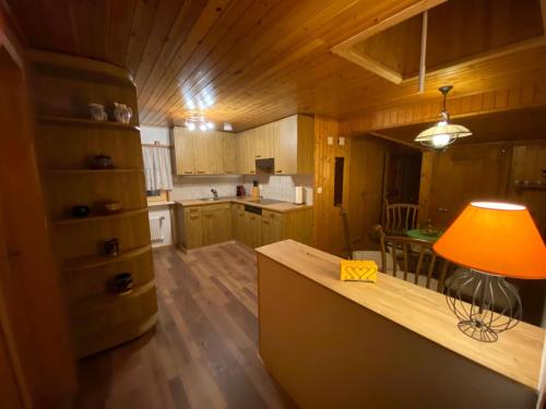 una cocina con armarios de madera y una mesa con lámpara. en Chalet Burglauenen Grindelwald, en Grindelwald