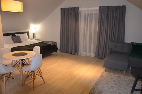 a hotel room with a bed and a table and chairs at Czarna Góra Haven in Sienna