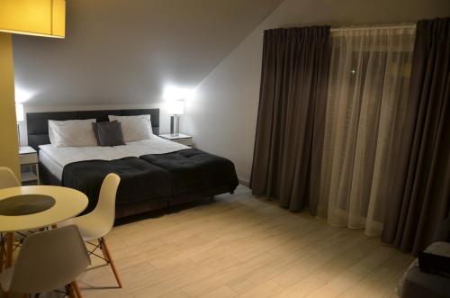 a bedroom with a bed and a table and chairs at Czarna Góra Haven in Sienna