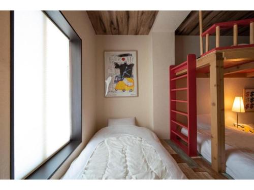 een slaapkamer met 2 stapelbedden en een raam bij BEYOND HOTEL Takayama 2nd - Vacation STAY 82239 in Takayama