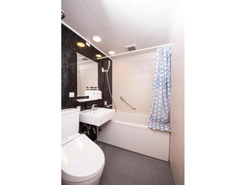 a bathroom with a toilet and a tub and a sink at BEYOND HOTEL Takayama 2nd - Vacation STAY 82239 in Takayama