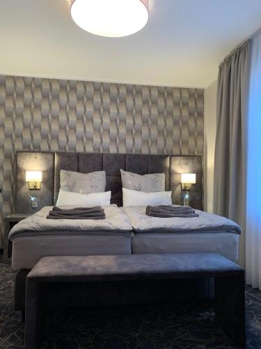 a bedroom with two beds and a large headboard at Gästehaus am Kurpark Hotel Garni in Horn-Bad Meinberg