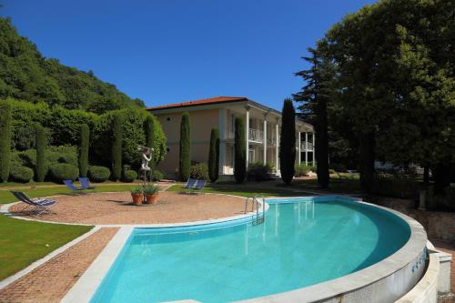 una piscina con due sedie e una casa di Lake Front 138 a Porto Ceresio