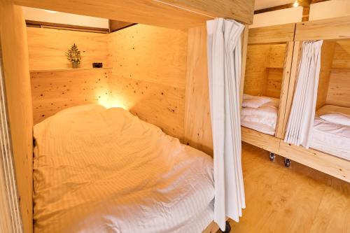 - une chambre avec 2 lits dans une cabane en bois dans l'établissement HIKE, à Nirasaki