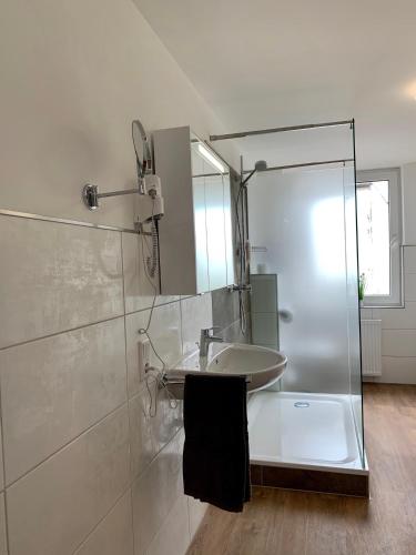 a bathroom with a sink and a shower at Gästehaus am Kurpark Hotel Garni in Horn-Bad Meinberg