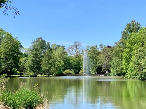 a pond in a park with a fountain in the middle at Gästehaus am Kurpark Hotel Garni in Horn-Bad Meinberg