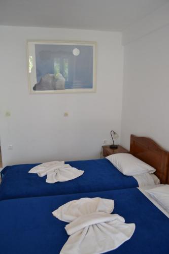 two beds in a room with towels on them at Studio Ioanna Tinos in Kionia