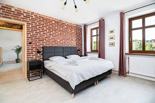una camera con un grande letto e un muro di mattoni di Blick Apartments - Riverview Soft Loft a Zgorzelec