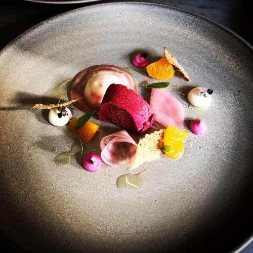 a plate of food with an apple and fruit on it at moser-HOCHKÖNIG Genuss Wirtshaus Hotel in Maria Alm am Steinernen Meer