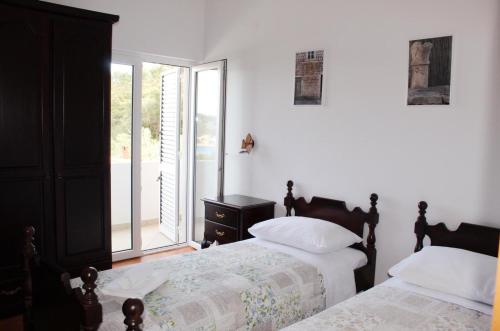 a bedroom with two beds and a window at Villa Šolta in Rogač