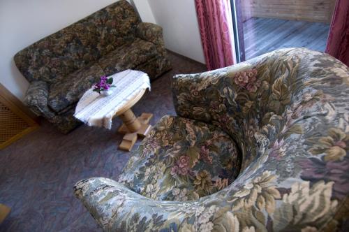 a living room with a couch and a chair at Sporthotel Spoegler in Collalbo