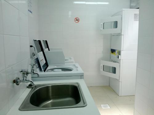 a small kitchen with a sink and a microwave at Departamento Aquamar in Viña del Mar