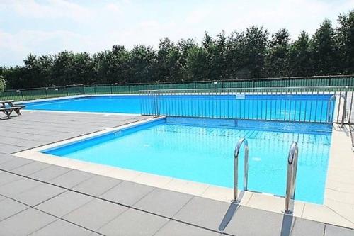 a large swimming pool with blue water in it at The Blue House - Luxurious Waterfront Villa Zeewolde in Zeewolde