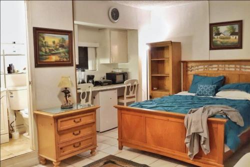 een kleine slaapkamer met een bed en een keuken bij COZY QUEEN BED STUDIO NEAR DOLPHIN MALL-FIU in Miami