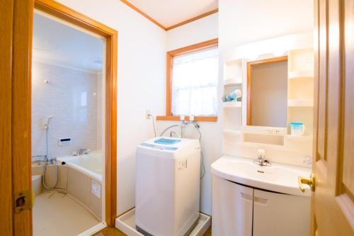 Un pequeño baño con lavabo y lavadora. en Minamitsuru-gun - House - Vacation STAY 82283, en Fujikawaguchiko