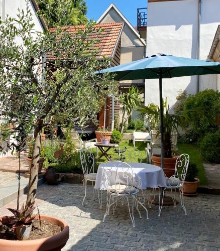 a patio with a table and chairs and an umbrella at Maison Dietenbeck in Wissembourg