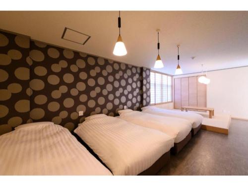 高山的住宿－BEYOND HOTEL Takayama 3rd - Vacation STAY 82215，带有圆点的房间的一排床