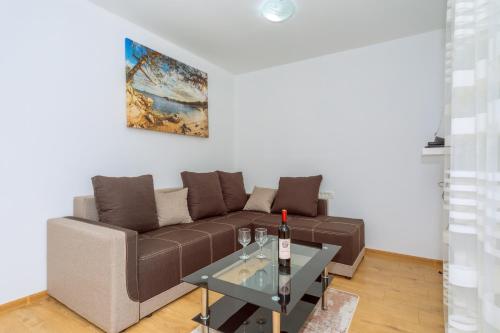 a living room with a brown couch and a table at Apartments EcoNature in Virpazar