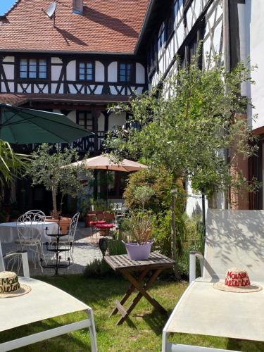 a garden with tables and chairs and a building at Maison Dietenbeck in Wissembourg