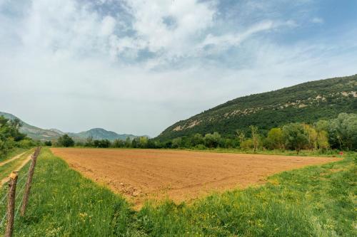 a dirt field with a hill in the background at Apartments EcoNature in Virpazar