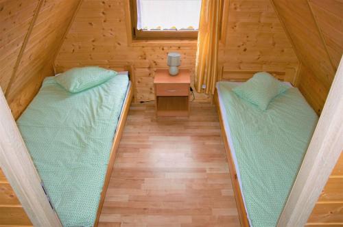 a room with two beds in a wooden house at Domki Letniskowe Orka in Jarosławiec