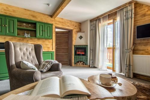 a living room with a coffee table with an open book at Villa Adamo & Relax in Zakopane