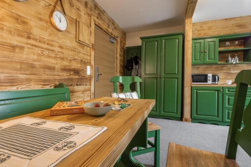 a kitchen with green cabinets and a wooden table at Villa Adamo & Relax in Zakopane