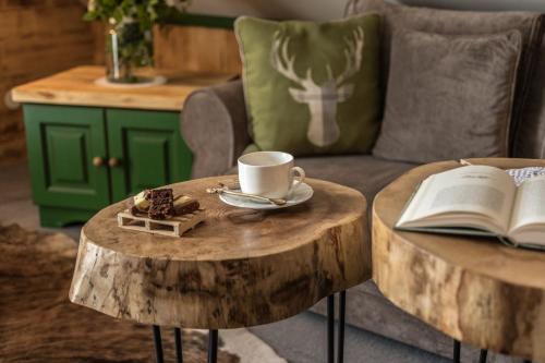 a coffee table with a cup of coffee and a book at Villa Adamo & Relax in Zakopane