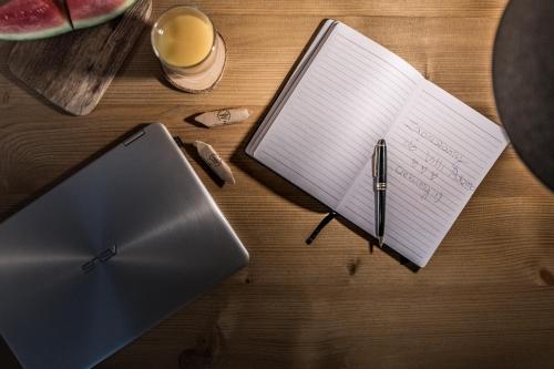 a desk with a notebook and a pen and a laptop at Villa Adamo & Relax in Zakopane