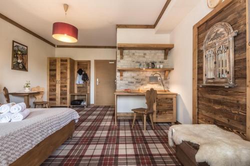 a bedroom with a bed and a desk in a room at Villa Adamo & Relax in Zakopane