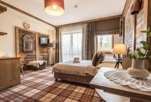 a hotel room with a bed and a living room at Villa Adamo & Relax in Zakopane