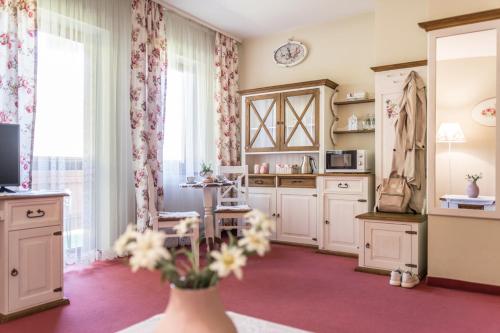 a kitchen with white cabinets and a vase with flowers at Villa Adamo & Relax in Zakopane