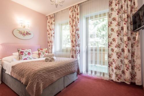 a bedroom with a bed and a window at Villa Adamo & Relax in Zakopane