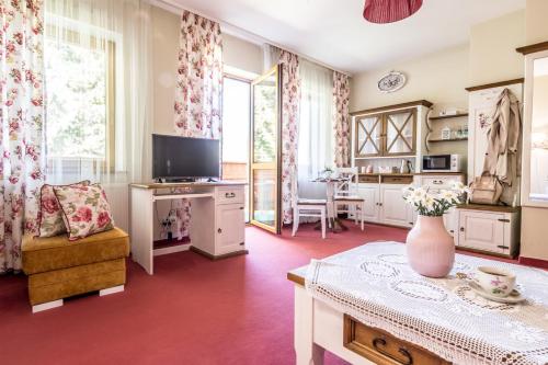 a living room with a vase of flowers on a table at Villa Adamo & Relax in Zakopane