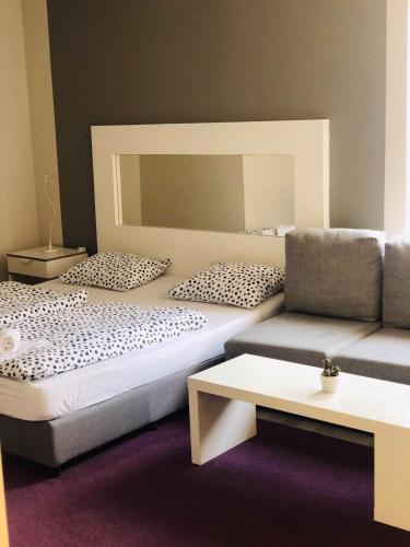 a room with two beds and a couch at Executive Rooms and Suites Play in Veliko Tŭrnovo