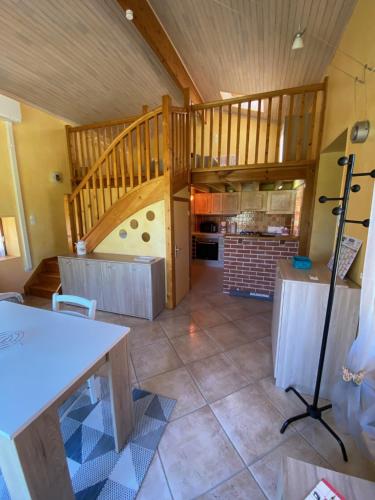 una grande stanza con scala e cucina di La petite maison dans le Quercy a Cayriech