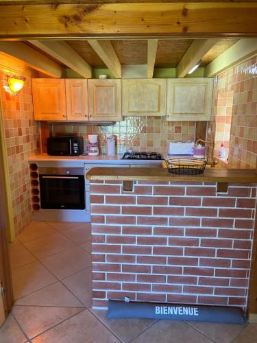 a kitchen with a brick counter top in a kitchen at La petite maison dans le Quercy in Cayriech