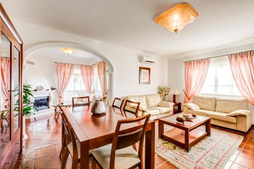 a living room with a table and a couch at Altura Prime 5 Suite Villa with Private Pool and Parking Walk to Beach in Altura